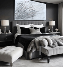A cozy and inviting modern bedroom with a large White Wabi Sabi wall art with 3D relief textures and silver details on the wall, a plush fur blanket on the bed, and large windows. The room features soft lighting and a gray carpet  to enhance the atmosphere