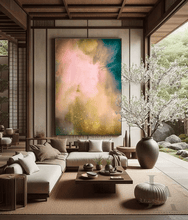 A large abstract canvas painting with soft pink, gold, and teal tones hangs on a wall in a modern Japanese-style living room with a low sofa, wooden coffee table, and a large vase with flowering branches.