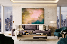 A large abstract canvas print with pink, gold, and teal tones hangs on a textured wall above a modern gray sofa in a luxury living room with city views.
