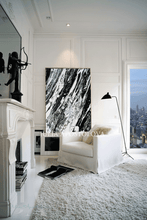 Modern living room with white walls, a white sofa, and a large black white abstract painting.