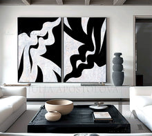 Modern living room with abstract black and white artwork on the wall.