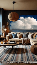 Cozy boho living room with two large celestial cloud paintings, a beige sofa, coffee table, and decorative rug.