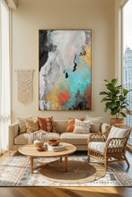 Living room with a colorful abstract painting on the wall, a beige sofa with cushions, a wooden coffee table, and a plant.