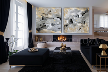 Modern living room with gold leaf abstract art set on the wall, black furniture, and decorative elements.