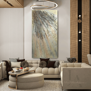 A modern and elegant living room with a large beige sectional sofa , a low coffee table with golden decorative items , and a large gold abstract painting on the wall. The room has a neutral color palette with warm lighting , creating a cozy and sophisticated atmosphere