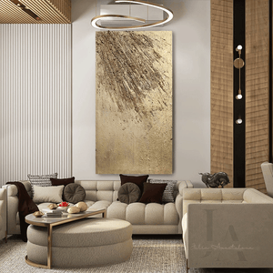 A modern and elegant living room with a large beige sectional sofa , a low coffee table with golden decorative items , and a large gold abstract painting on the wall. The room has a neutral color palette with warm lighting , creating a cozy and sophisticated atmosphere