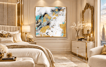 An abstract canvas wall art painting with gold, blue, black, and white brushstrokes, displayed in a luxurious modern bedroom setting with a bed, gold-framed mirror, and city view.