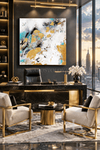 A large square abstract canvas painting with real gold leaf, teal, black, and white brushstrokes hangs on a dark gray wall above a modern black marble desk in a luxury office setting with two beige armchairs and a city skyline view.