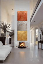 Modern living room with a gold copper silver 3d wall paining by Julia Apostolova, a fire pit, white couch, plants, and garden view.
