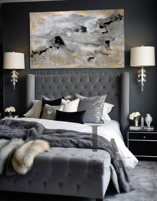 Modern bedroom with gray tufted headboard, gold leaf abstract painting, and decorative elements.