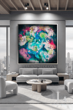 A large framed abstract wall art print featuring vibrant swirling colors of blue, green, pink, purple, and yellow on a dark background, displayed in a modern living room setting above a gray sofa.