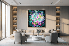 A large framed abstract floral painting with vibrant teal, purple, pink, and blue tones hangs on a light wood wall above a modern beige sofa in a bright, contemporary living room.