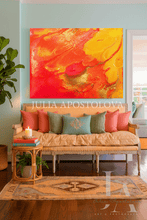 Living room with a colorful orange abstract painting, beige sofa, and decorative pillows.