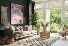 Modern living room with a gray sofa, pink abstract painting, and large windows with garden view.