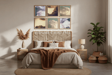 Neatly made bed with decorative pillows, 6 framed cloud wall art, over the headboard in a bedroom setting.