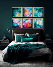 A styled bedroom scene with a bed dressed in white and teal bedding, set against a dark teal wall. Above the bed, six framed abstract floral paintings in teal, pink, yellow, and purple hang in two rows of three.