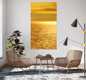 Modern living room with wicker chairs, a small table, and a large abstract painting of a sunset over water.