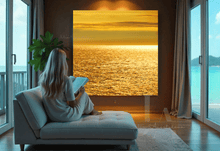 Woman sitting on a couch in a living room with a large abstract painting of a sunset.