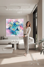 Woman holding a colorful abstract painting in a modern living room.