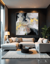 Modern living room with a gray sectional sofa, abstract painting, and decorative items.