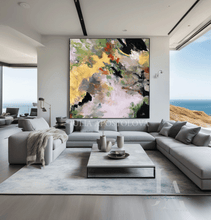 Modern living room with a large abstract painting on the wall, by artist Julia Apostolova. The room featuring a scenic ocean view.