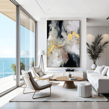 Modern living room with ocean view, large gold leaf abstract painting, and stylish furniture.
