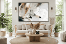 Modern living room with a large abstract painting, beige sofa, and decorative plants.