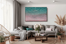 Modern living room with a large seascape wall art, gray sectional sofa, coffee table, and decorative elements.
