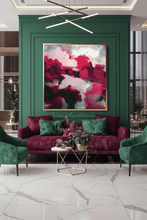 A modern living room featuring a large abstract painting with bold pink, red, and white brushstrokes hanging on a deep green paneled wall above a magenta velvet sofa with matching green pillows.