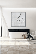A minimalist black line art of a female torso profile on a textured light white background, displayed in a modern white bathroom setting above a freestanding bathtub.