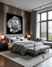 Modern bedroom with a large bed, black white artwork on the wall, and large windows.