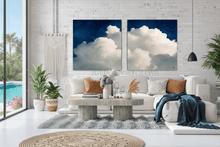 Living room with a white sofa, coffee table, and two cloud-themed wall art pieces.