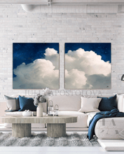 Two extra large celestial cloud-themed wall art paintings above a white modern living room sofa.