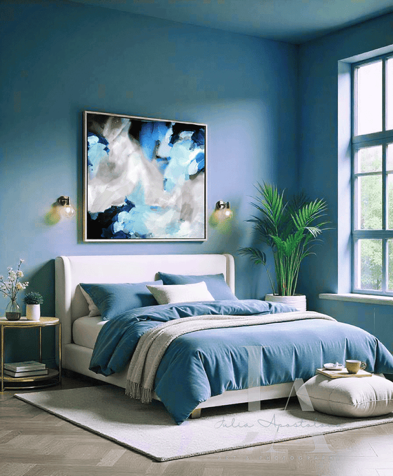 Modern bedroom with blue walls and bedding, Blue and Gray Painting hanging over the bed, pouf, plants and decor elements