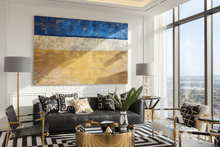 Modern living room with minimalist blue gold abstract art, black sofa, and large windows.