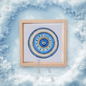 A framed mandala-like design with intricate blue white and gold patterns against a cloudy sky background.  Ideal art gift for Christmas, Valentine's Day, Birthday, and any occasion. 