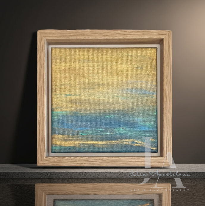 Framed abstract minimalist painting with a gradient of gold to blue on a dark background