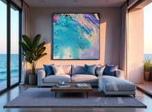 Modern living room with a large abstract painting, gray sofa, and ocean view.