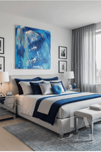 A modern bedroom featuring a large, vibrant blue abstract canvas painting on the wall above a neatly made bed with blue and white bedding. The room has gray curtains, a gray patterned rug, and a light gray upholstered bench at the foot of the bed.