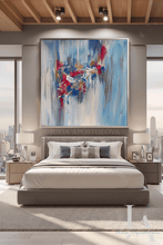 A large framed abstract painting with blue, white, dark pink, and gray brushstrokes hangs above a bed in a modern bedroom with city views, nightstands, lamps, and wood ceiling beams.