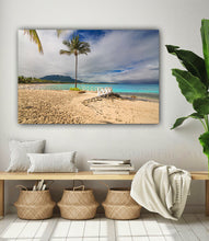 Beach scene painting on a wall above a wooden bench with decorative items.