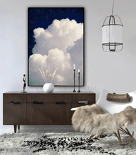 Large white cloud against a navy blue celestial sky painting , hanging over dark 
wooden cadenza , in modern minimalist boho living room setting. 