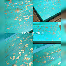 Close-up details of a turquoise painting with gold leaf patterns.
