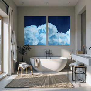 Modern bathroom with a freestanding bathtub, two large cloud paintings on the wall, and natural light.