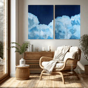 Modern living room with a wicker chair, side table, and cloud-themed wall art.