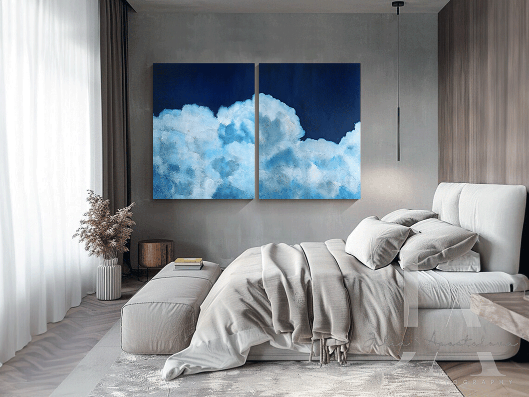 Modern bedroom with a large bed and two cloud-themed wall art pieces.