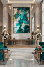 A large abstract wall art piece with swirling teal, green, blue, pink, and cream brushstrokes hangs in a luxurious modern lobby with marble walls, gold-framed mirrors, teal armchairs, and floral arrangements.