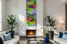 A modern living room with two tall vertical abstract wall art panels hanging above a fireplace. The artwork features vivid blue, green, yellow, and pink brushstrokes.