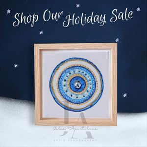 An original elegant abstract greek eye painting in mandala-like design with concentric circles in shades of blue , gold glitter, and white, framed and displayed against a dark blue background with stars. Perfect greek evil eye art gift for protection, for Christmas, Valentine's Day, Birthday, and any occasion.