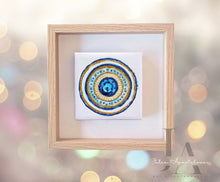 A greek eye original painting with glitter gold and blue color scheme, framed in a simple, wooden frame. Will be perfect elegant gift for someone special.